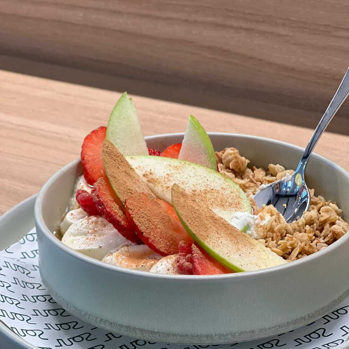 A picture of a bowl of granola with a spoon